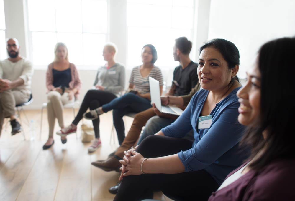A smiling group of an individuals at a meeting or retreat.